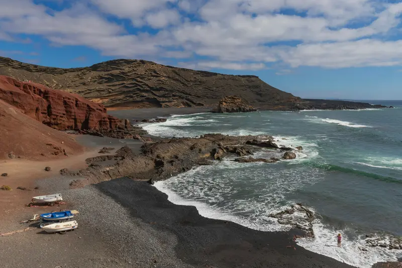 Small boats on a black volcanic beach in Lanzarote