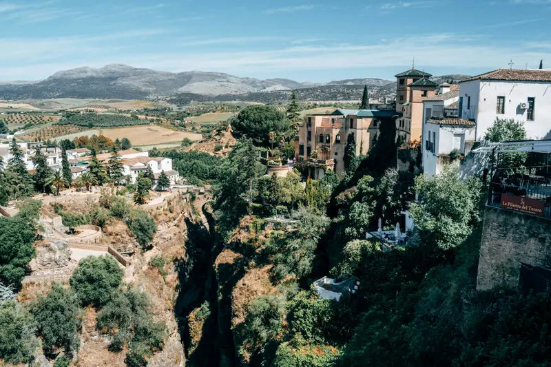 White houses of Ronda on the edge of a deep green gorge in Andalusia